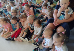 Niedźwiadki wraz z dziećmi z przedszkola z zaciekawieniem oglądające występ artysty.